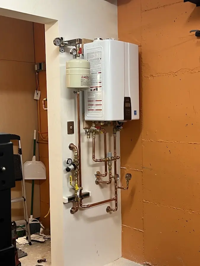 Plumbing technician inspecting water heater connections in Bayonne